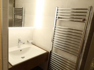 a white bathroom with a sink and a shower at Apartment Dents Rousses B4 by Interhome in Siviez