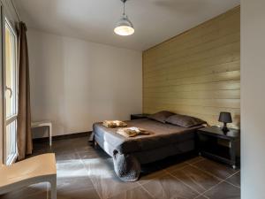 a bedroom with a bed and a wooden wall at Apartment Residence Marina di Favone- T3- 4-6 pers-2 by Interhome in Favone
