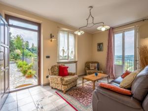ein Wohnzimmer mit einem Sofa und Stühlen sowie einer Glasschiebetür in der Unterkunft Apartment San Michele-1 by Interhome in Vinchio