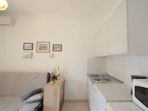 a white kitchen with a sink and a counter at Apartment Neda by Interhome in VeliGolji