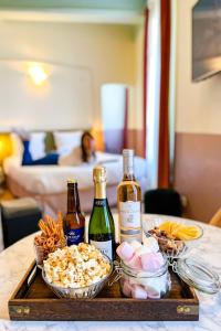 ein Tablett mit zwei Flaschen Wein und Snacks auf dem Tisch in der Unterkunft Aparthotel AMMI Vieux Nice in Nizza