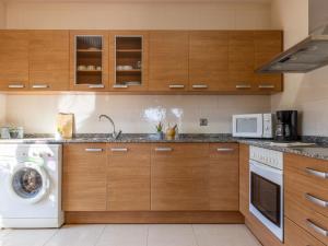 eine Küche mit Waschmaschine und Mikrowelle in der Unterkunft Holiday Home Alex by Interhome in Riumar + 25 Fotos