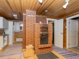 einen gemauerten Kamin in der Mitte eines Zimmers in der Unterkunft Holiday Home Viipusjärvi 10 by Interhome in Ruka + 13 Fotos
