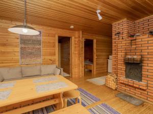 ルカにあるHoliday Home Viipusjärvi 12 by Interhomeのリビングルーム(テーブル、レンガ造りの暖炉付)