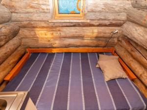 ルカにあるHoliday Home Saarenkainalo by Interhomeのログキャビン内のベッド1台が備わる客室です。