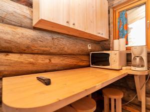 a wooden table with a microwave and acomputer on it at Holiday Home Saarenkainalo by Interhome in Ruka