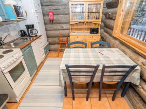 a kitchen with a table and chairs in a tiny house at Holiday Home Pajalan honka by Interhome in Nissi