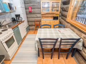 eine Küche mit einem Tisch und Stühlen in einem winzigen Haus in der Unterkunft Holiday Home Pajalan honka by Interhome in Kuusamo
