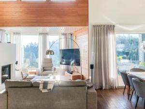 a living room with a couch and a large window at Holiday Home Rukavuorenhuippu 23 a by Interhome in Ruka