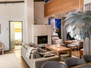 a living room with a couch and chairs and a fireplace at Holiday Home Rukavuorenhuippu 23 a by Interhome in Ruka