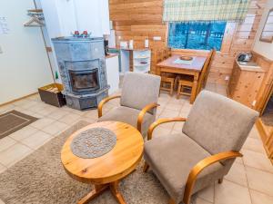 sala de estar con mesa, sillas y estufa de leña en Holiday Home Villa kuukkeli by Interhome, en Kuusamo