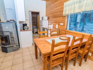 a kitchen and dining room with a table and a stove at Holiday Home Villa kuukkeli by Interhome in Kuusamo