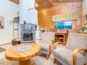 クーサモにあるHoliday Home Villa kuukso by Interhomeのリビングルーム(テーブル、椅子、暖炉付)