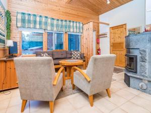 a living room with a couch and a table and chairs at Holiday Home Villa kuukso by Interhome in Kuusamo
