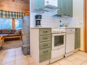 a kitchen with green cabinets and a stove at Holiday Home Villa kuukso by Interhome in Kuusamo