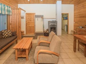 a living room with a couch and a table and a stove at Holiday Home Villa kuusanka by Interhome in Kuusamo