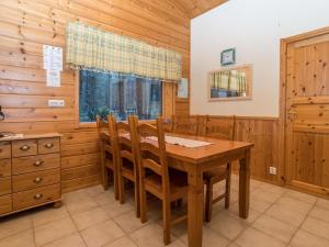 a dining room with a wooden table and chairs at Holiday Home Villa kuusanka by Interhome in Kuusamo