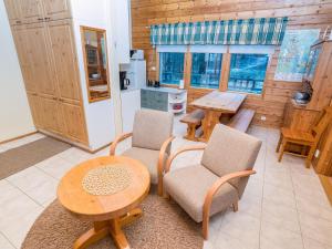 a living room with a table and chairs and a kitchen at Holiday Home Villa hilla by Interhome in Kuusamo