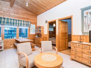a room with a table and chairs and a kitchen at Holiday Home Villa hilla by Interhome in Kuusamo