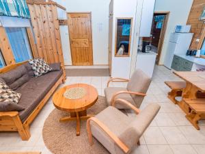 een woonkamer met een bank, stoelen en een tafel bij Holiday Home Villa lakka by Interhome in Kuusamo