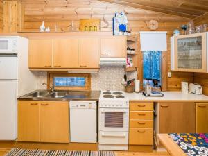 eine Küche mit weißen Geräten und Holzschränken in der Unterkunft Holiday Home Pohjaskoti a by Interhome in Ruka