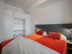 um quarto com uma cama grande e um cobertor laranja em Holiday Home Nordic chalet 9410 by Interhome em Ylläs