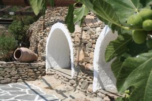 a stone wall with a vase sitting on top of it at Petra Holiday Village in Ios Chora