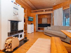 ein Wohnzimmer mit Couch und Kamin in der Unterkunft Holiday Home Pohjaskoti b by Interhome in Ruka