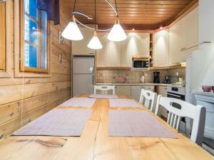 ユッラスヤルヴィにあるHoliday Home Ylläs outa 1 by Interhomeのキッチン(大きな木製テーブル、椅子付)