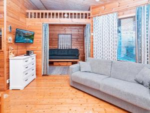 ein Wohnzimmer mit einer Couch und einem Sessel in der Unterkunft Holiday Home Pohjaskoti b by Interhome in Ruka