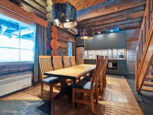 uma cozinha com uma mesa de madeira e cadeiras em Holiday Home Kaamosgammi by Interhome em Ylläs