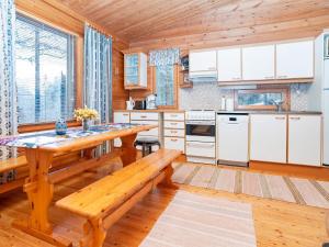 eine Küche mit weißen Schränken und einem Holztisch in der Unterkunft Holiday Home Pohjaskoti b by Interhome in Ruka + 13 Fotos