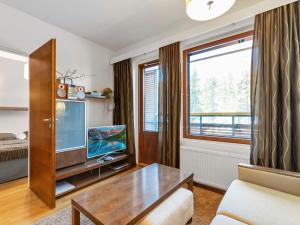 ein Wohnzimmer mit einem TV und einem Tisch in der Unterkunft Holiday Home Ylläs chalets 2405 by Interhome in Ylläs