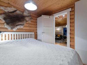 ユッラスヤルヴィにあるHoliday Home Felixinpolku 2 by Interhomeの白いベッドと木製の壁が備わるベッドルーム1室が備わります。