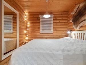 um quarto com uma cama num chalé de madeira em Holiday Home Felixinpolku 2 by Interhome em Ylläsjärvi