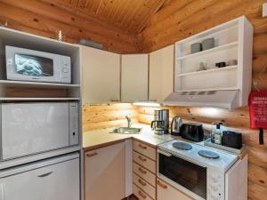 uma cozinha com um fogão e um micro-ondas em Holiday Home Felixinpolku 2 by Interhome em Ylläsjärvi