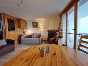 Apartment Butte aux Noëls 206 by Interhome في فيربير: غرفة معيشة مع طاولة خشبية مع وجود كوبين عليها