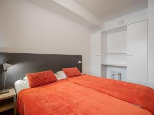 a bedroom with a bed with an orange blanket at Holiday Home Nordic chalet 9211 by Interhome in Ylläs