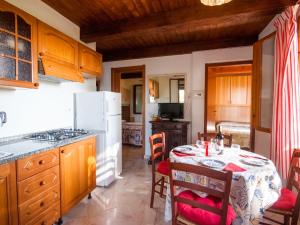 a kitchen with a table and a white refrigerator at Holiday Home Piccola Oasi 7 by Interhome in Capoliveri +34 photos