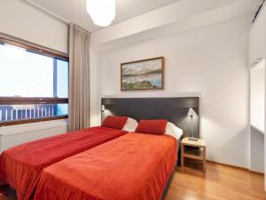 een slaapkamer met een groot bed en een rode deken bij Holiday Home Ski chalet vii 7406 by Interhome in Ylläs