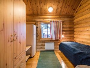 ユッラスヤルヴィにあるHoliday Home Kuukkelintupa 1 by Interhomeの木造キャビン内のベッド1台が備わるベッドルーム1室を利用します。
