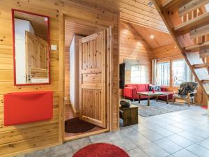 ユッラスヤルヴィにあるHoliday Home Kultapiisku 3 by Interhomeの木製の壁のリビングルーム(赤いソファ付)
