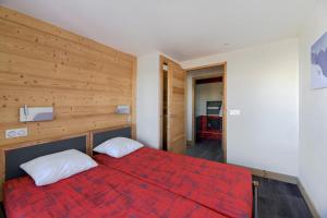 a bedroom with a red bed with two white pillows at Noemys Backgammon in La Plagne