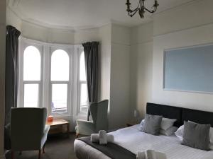 a bedroom with a bed and a large window at The Oasis in Llandudno