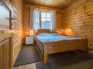 ein Schlafzimmer mit einem Bett in einer Blockhütte in der Unterkunft Holiday Home Patrakka by Interhome in Alvettula