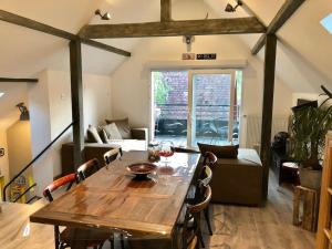 a dining room with a wooden table and chairs at Le Logis du Vignoble in Kintzheim