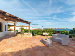 Un patio con un sofá y sillas y una mesa. en Villa Anita by Interhome, en Palau