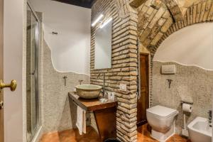 La salle de bains est pourvue d'un mur en pierre, d'un lavabo et de toilettes. dans l'établissement Luxury Navona, à Rome 35 autres photos