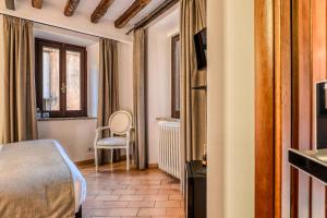 ein Schlafzimmer mit einem Bett und einem Stuhl in einem Zimmer in der Unterkunft Luxury Navona in Rom