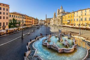 a fountain in the middle of a street with buildings at Luxury Navona in Rome